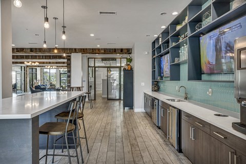 a large kitchen with a large counter and chairs and a tv